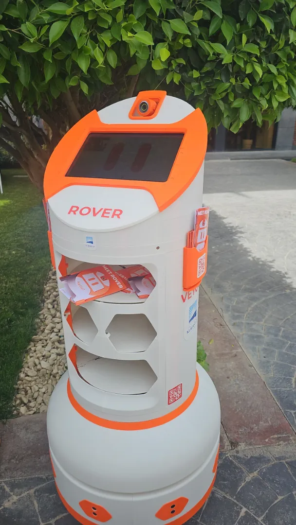 Rover outdoors in a courtyard with flyers loaded in its side pockets and cargo bay
